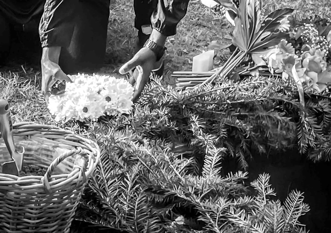 Handen leggen bloemen bij een graf
